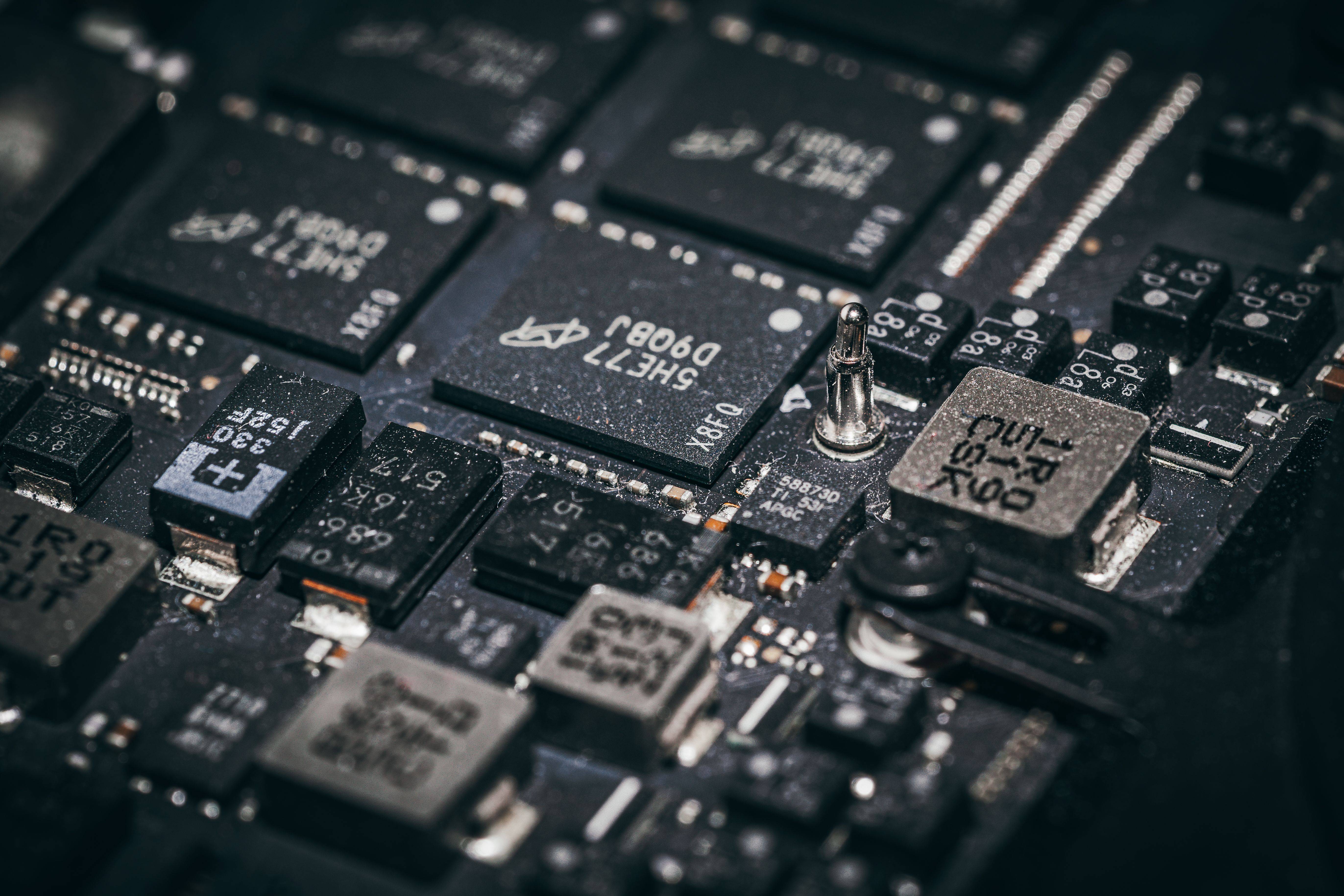 Nahaufnahme einer Hauptplatine mit Speicherchips, Spulen und Kondensatoren